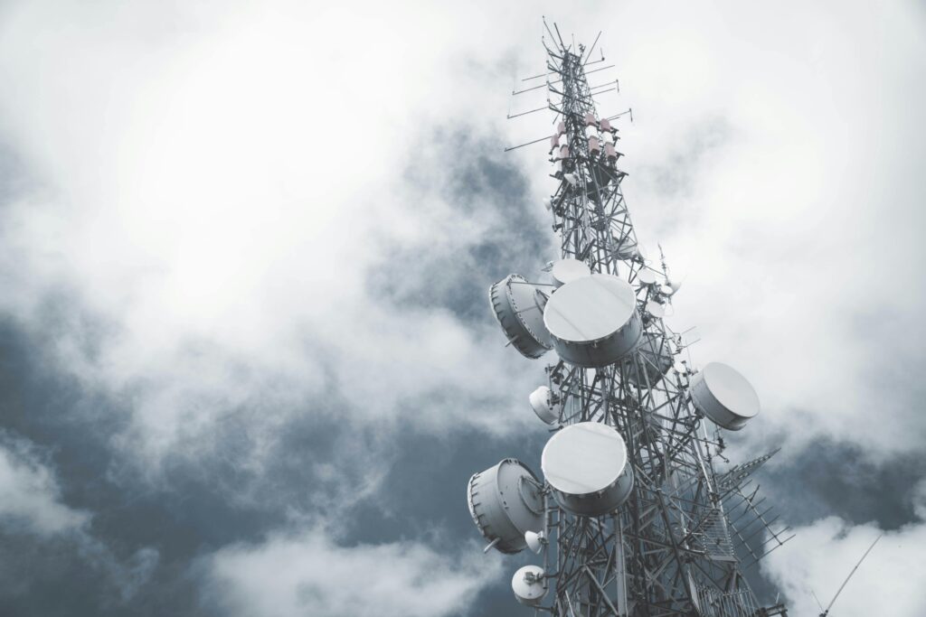 pexels-photo-10259517-10259517 A towering communication mast with satellite dishes, set against a cloudy sky.